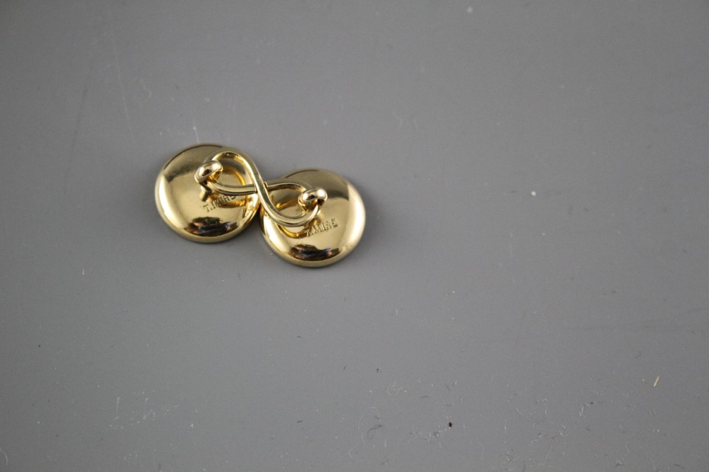 A pair of yellow metal (stamped TM 18ct), mother of pearl and enamel disc cufflinks, gross weight 10 grams, disc 14mm.